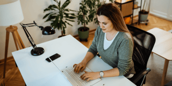 hybrid worker woman in home office working on laptop