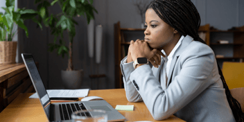 woman looking upset staring at laptop IT network downtime unable to work business