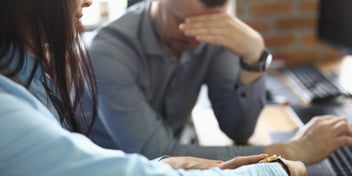 frustrated man and woman in office upset about network downtime being unproductive